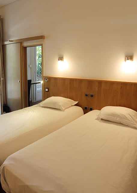 Family room - 25 m² at the Hôtel Belleville in Lamalou-les-Bains, with 2 single beds